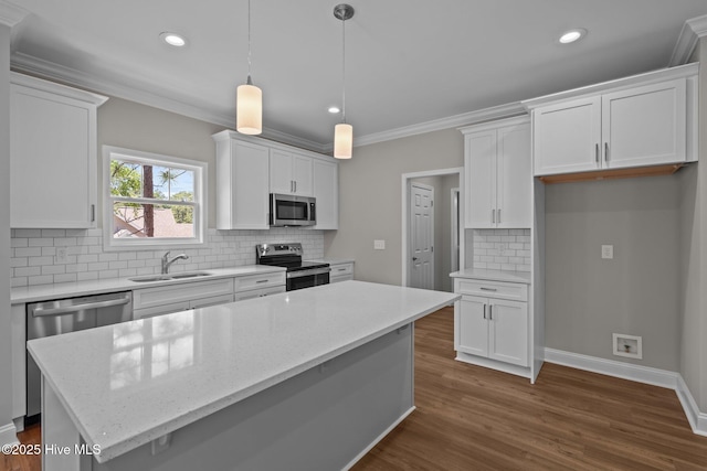 kitchen with appliances with stainless steel finishes, a sink, white cabinets, dark wood-style floors, and backsplash