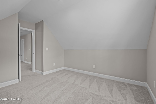 additional living space featuring carpet flooring, lofted ceiling, and baseboards