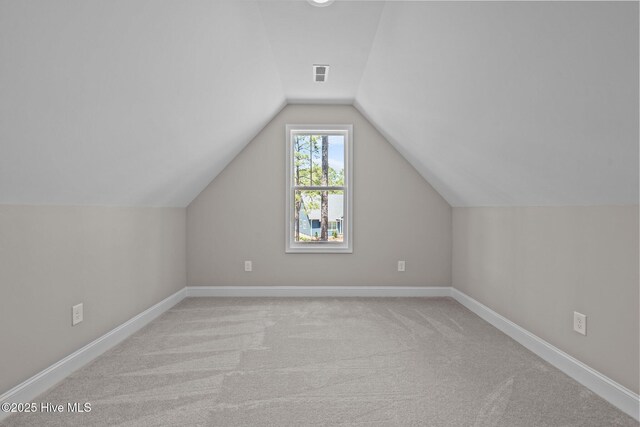 bonus room featuring lofted ceiling, carpet floors, and baseboards
