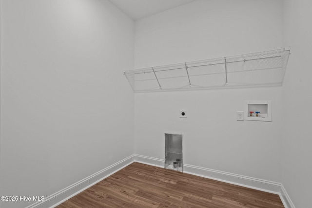 laundry area with hookup for an electric dryer, hookup for a washing machine, wood finished floors, and baseboards