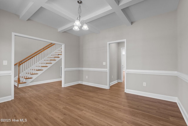 unfurnished room featuring a chandelier, stairs, wood finished floors, baseboards, and coffered ceiling