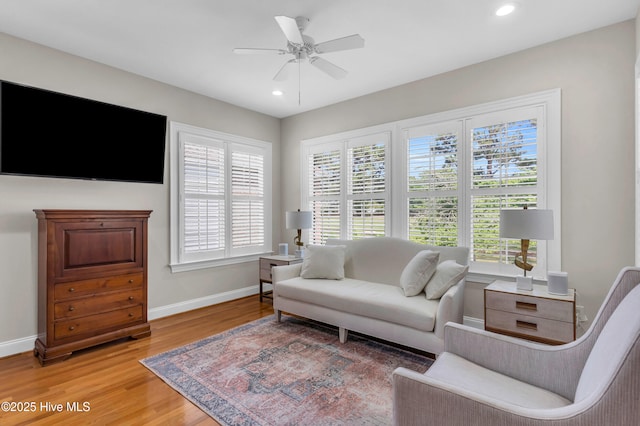 living room featuring recessed lighting, baseboards, a ceiling fan, and light wood-type flooring