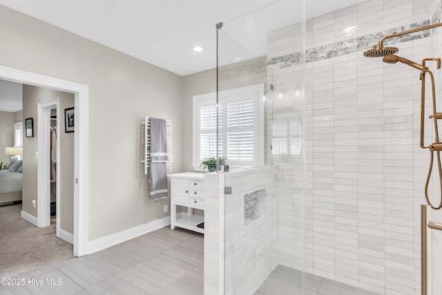 ensuite bathroom featuring connected bathroom, baseboards, and a shower stall
