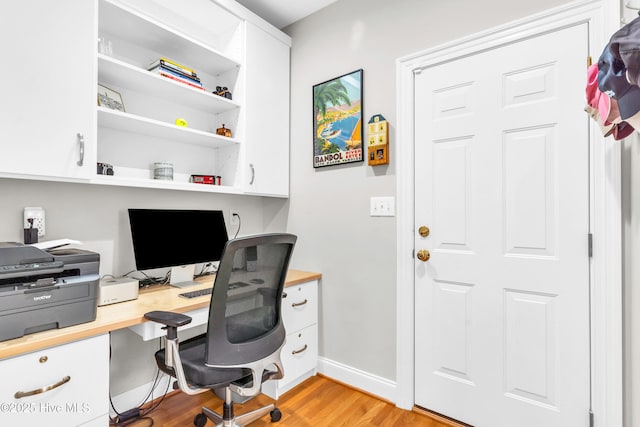 office space with baseboards and light wood-style flooring