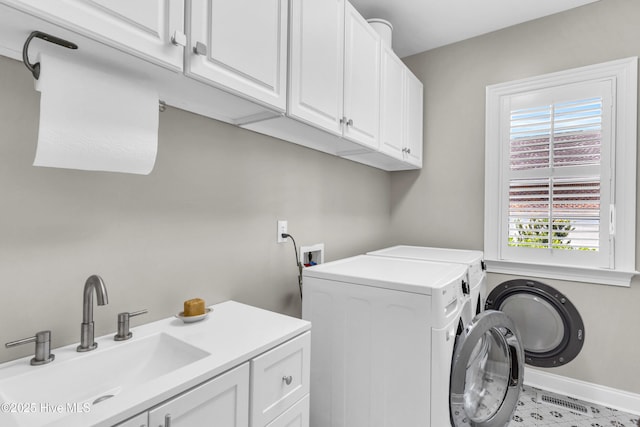 washroom with independent washer and dryer, baseboards, cabinet space, and a sink
