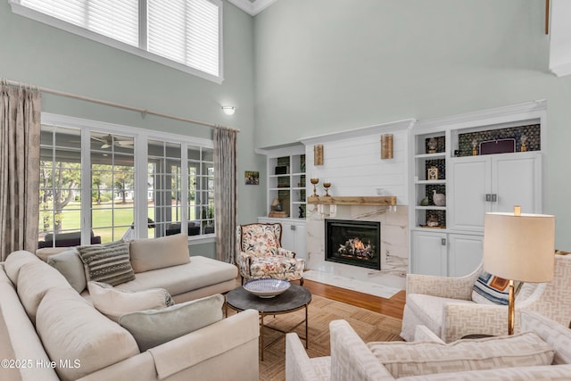 living room with a premium fireplace and a high ceiling