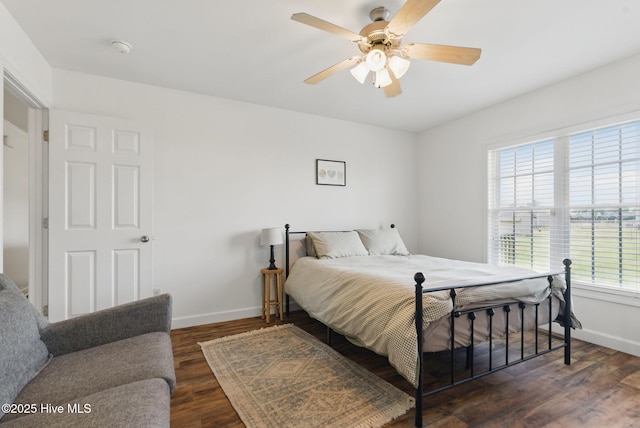 bedroom featuring wood finished floors, baseboards, and a ceiling fan