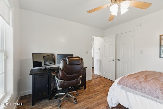 bedroom with baseboards, wood finished floors, and a ceiling fan