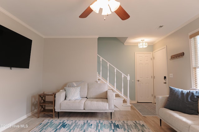living room featuring ornamental molding, wood finished floors, stairway, ceiling fan, and baseboards