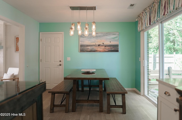dining area featuring light wood finished floors and baseboards