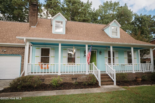 cape cod house with covered porch, crawl space, an attached garage, and a chimney
