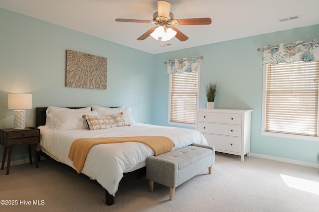 bedroom with light colored carpet, baseboards, and a ceiling fan