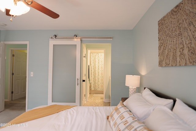 bedroom with baseboards, ensuite bathroom, and a ceiling fan