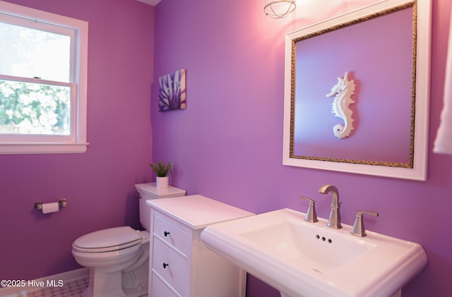 bathroom with a sink, toilet, baseboards, and tile patterned floors