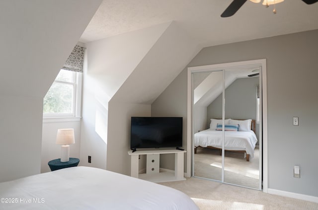 carpeted bedroom featuring vaulted ceiling, a closet, and ceiling fan