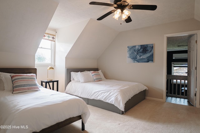 carpeted bedroom featuring vaulted ceiling, a ceiling fan, and a textured ceiling