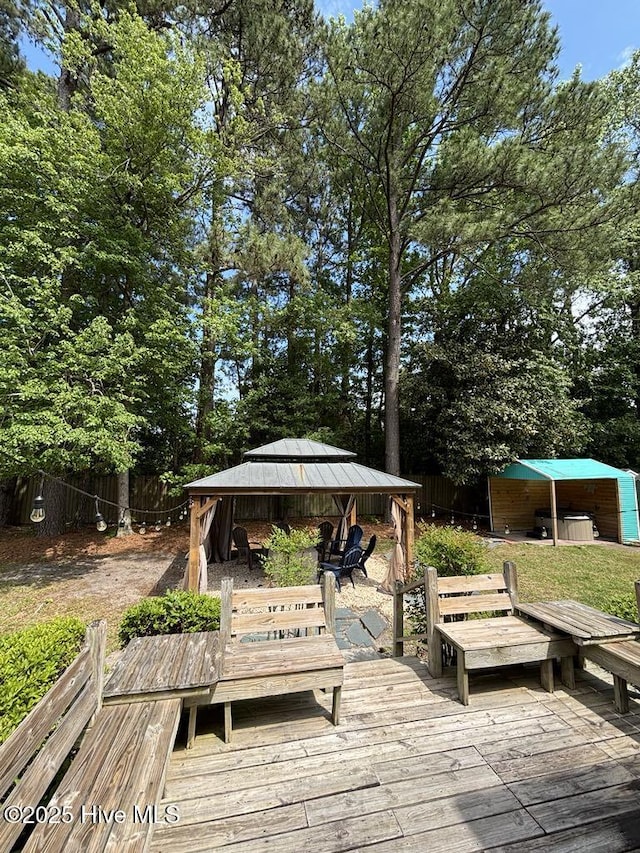 wooden terrace featuring a gazebo and fence