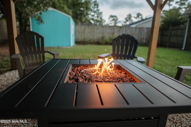 view of patio / terrace with an outdoor fire pit, an outbuilding, and a shed
