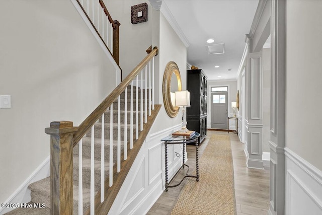 489 Broomsedge Ct SE, Bolivia, NC 28422 - stairs featuring a decorative wall, ornamental molding, a wainscoted wall, and wood finished floors