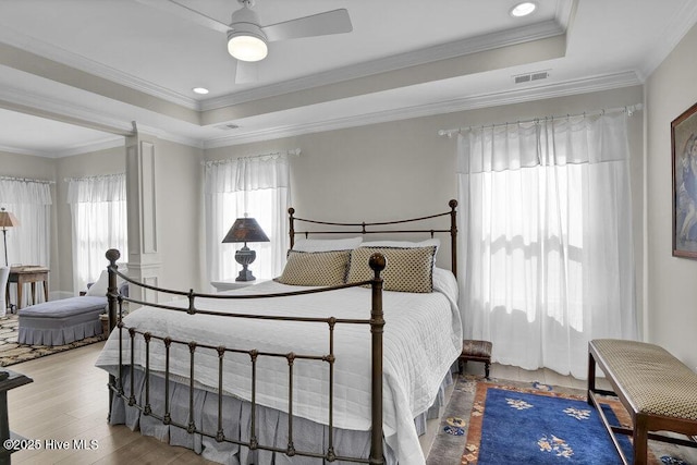 489 Broomsedge Ct SE, Bolivia, NC 28422 - bedroom featuring a tray ceiling, wood finished floors, ornamental molding, and a ceiling fan