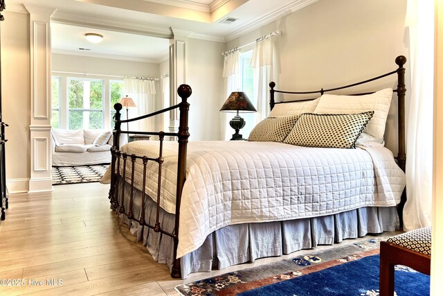 489 Broomsedge Ct SE, Bolivia, NC 28422 - bedroom featuring ornate columns, wood-type flooring, multiple windows, and crown molding