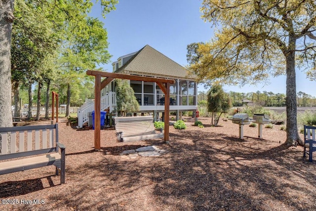 489 Broomsedge Ct SE, Bolivia, NC 28422 - back of house with a sunroom, stairs, and a shingled roof