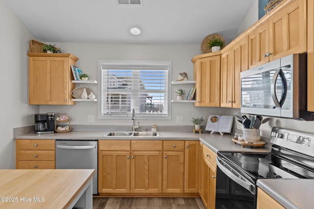 126 S Permuda Wynd Dr, North Topsail Beach, NC 28460 - kitchen featuring appliances with stainless steel finishes, a sink, open shelves, light wood-style floors, and light brown cabinetry