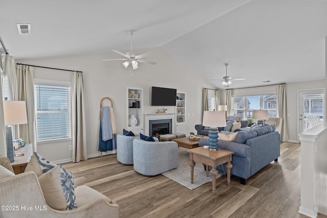 126 S Permuda Wynd Dr, North Topsail Beach, NC 28460 - living room featuring ceiling fan, light wood finished floors, vaulted ceiling, built in shelves, and a fireplace