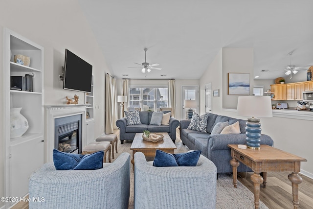 126 S Permuda Wynd Dr, North Topsail Beach, NC 28460 - living area featuring a ceiling fan, wood finished floors, a glass covered fireplace, and vaulted ceiling