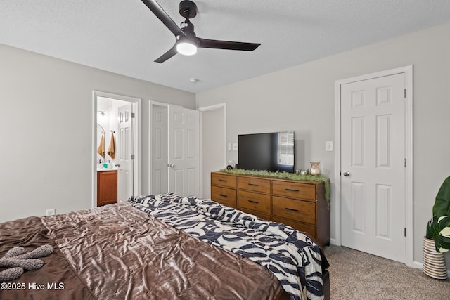 bedroom featuring light carpet, a ceiling fan, and connected bathroom