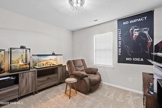 sitting room with baseboards, light carpet, a textured ceiling, and visible vents