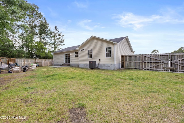 rear view of house featuring a yard, central AC, a fenced backyard, and entry steps