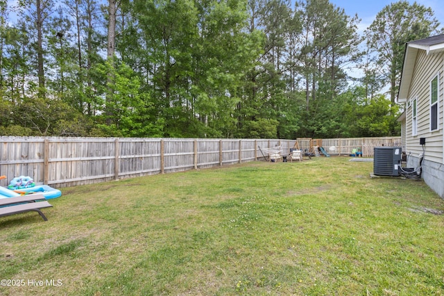 view of yard featuring central AC unit and a fenced backyard