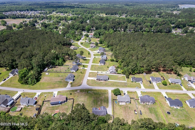 drone / aerial view featuring a view of trees and a residential view