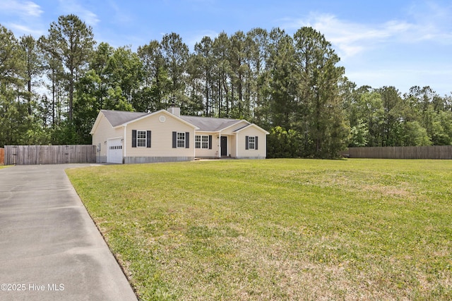 view of front of home featuring fence, an attached garage, concrete driveway, and a front yard