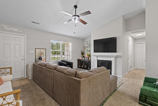living room featuring carpet floors, ceiling fan, visible vents, and a fireplace