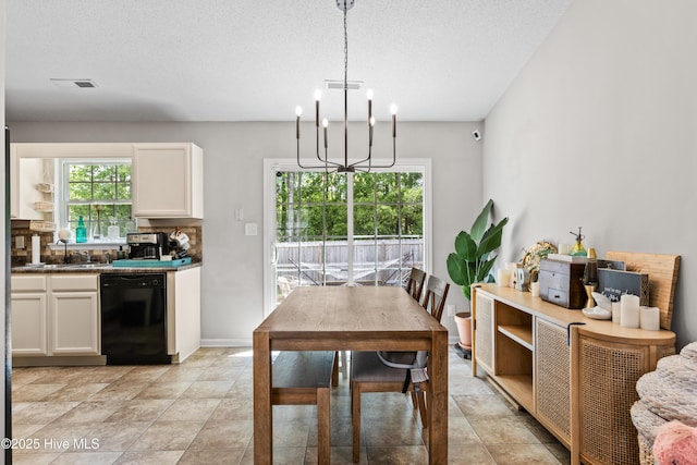 dining area with visible vents, a textured ceiling, and a chandelier