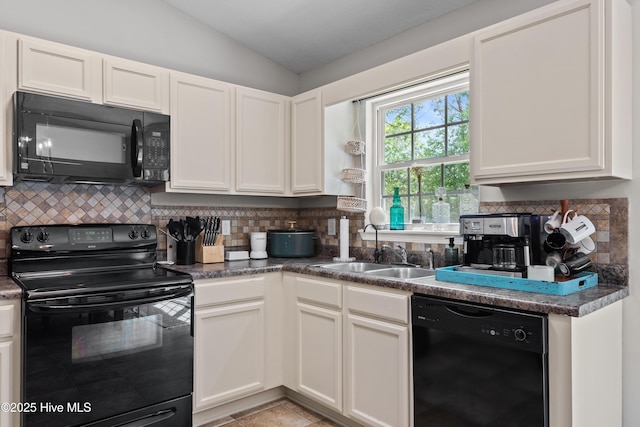kitchen with a sink, white cabinetry, lofted ceiling, backsplash, and black appliances