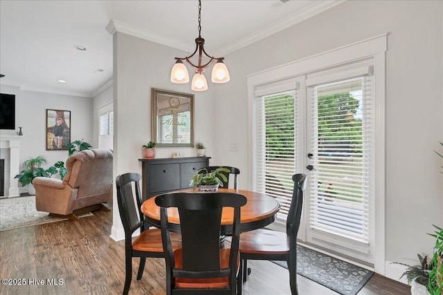 dining room with plenty of natural light, crown molding, wood finished floors, and a chandelier