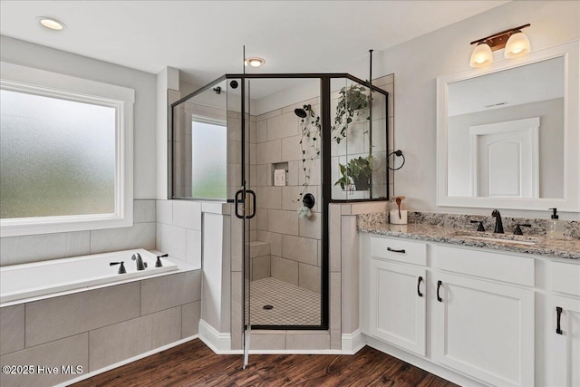 bathroom featuring a stall shower, vanity, and wood finished floors