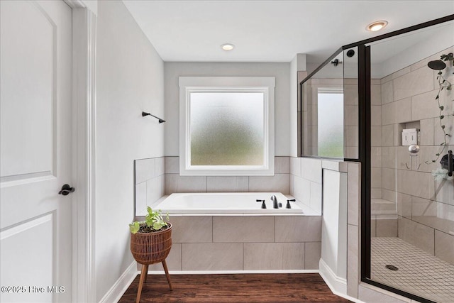 full bath with a stall shower, wood finished floors, and a garden tub