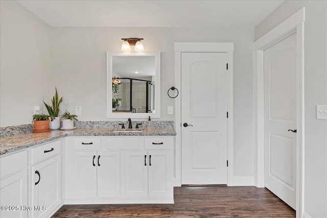 full bath featuring wood finished floors, a stall shower, and vanity