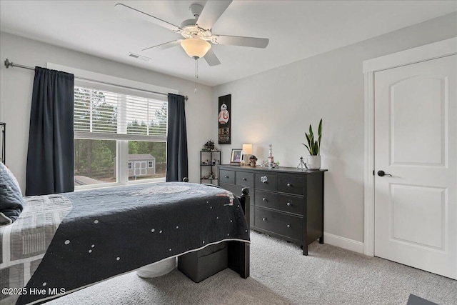 bedroom with light carpet, baseboards, and a ceiling fan