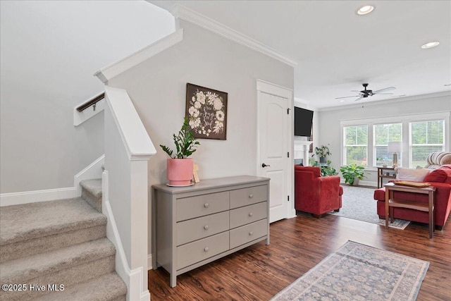 living area featuring dark wood-type flooring, recessed lighting, crown molding, ceiling fan, and stairway
