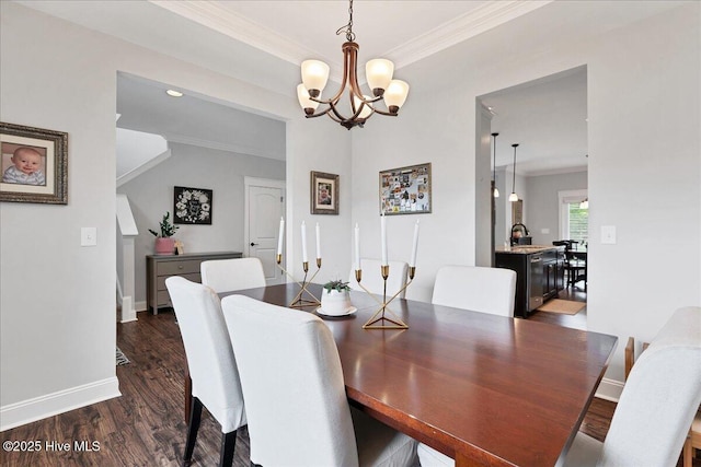 dining room with ornamental molding, a chandelier, dark wood finished floors, and baseboards