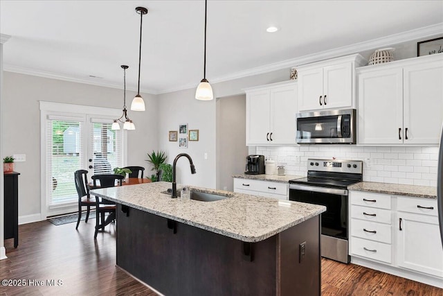 kitchen featuring stainless steel appliances, a sink, an island with sink, backsplash, and dark wood-style flooring