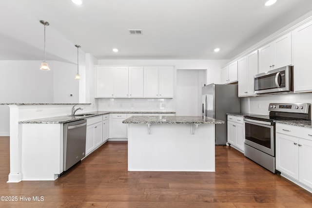 365 W Goldeneye Ln, Sneads Ferry, NC 28460 - kitchen featuring stainless steel appliances, a chandelier, white cabinets, dark wood-style flooring, and dark stone counters