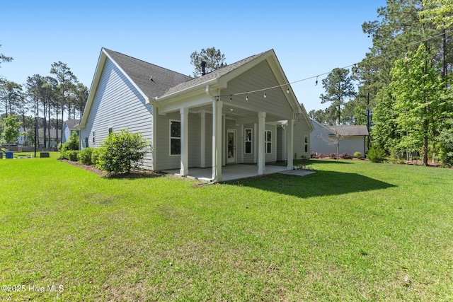 365 W Goldeneye Ln, Sneads Ferry, NC 28460 - back of property with a patio, a lawn, and a shingled roof
