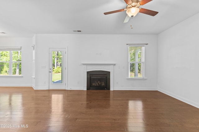 365 W Goldeneye Ln, Sneads Ferry, NC 28460 - unfurnished living room featuring a glass covered fireplace, hardwood / wood-style flooring, ceiling fan, and baseboards