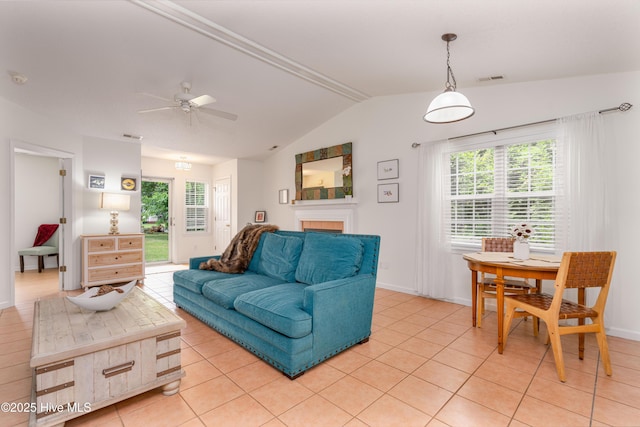 living area with light tile patterned flooring, a ceiling fan, baseboards, and lofted ceiling